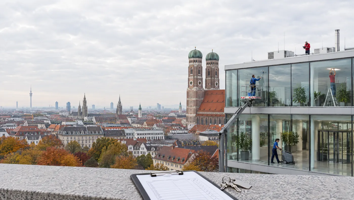 Gebäudedienstleister bei der Arbeit: Glasreinigung, Haustechnik und Bodenreinigung in einem Bürogebäude
